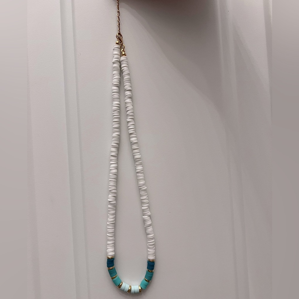 White necklace with green ombré pattern with gold accents